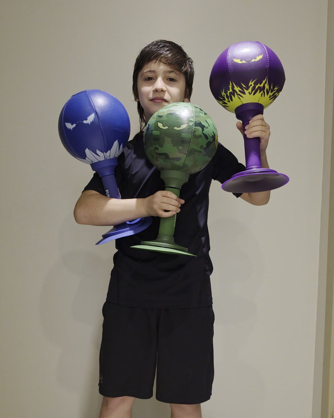 El Buho Ciro holding blue, camouflage, and purple FUNPUNCH Rage-Bags